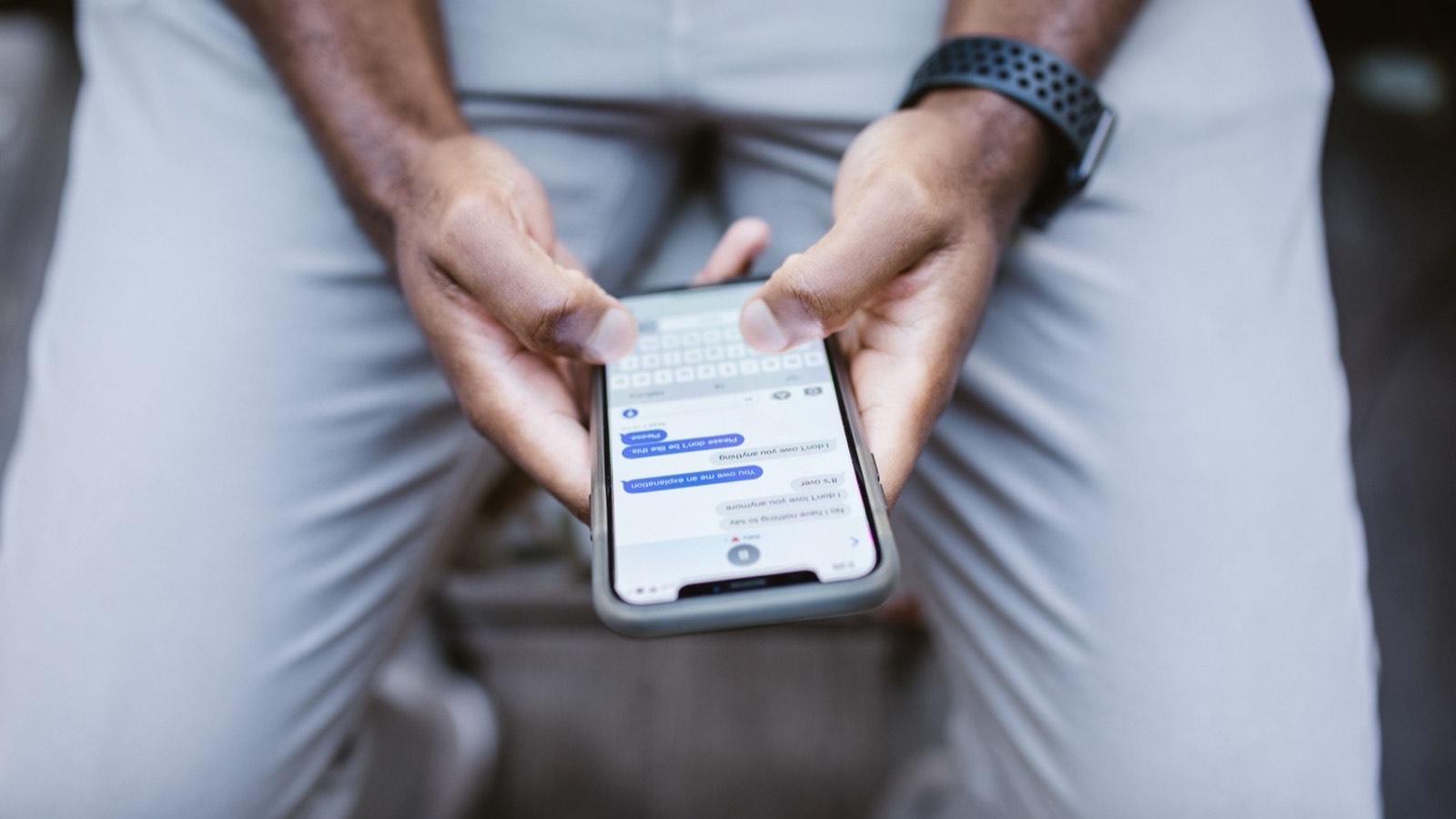Hands holding a phone with a chat message on screen