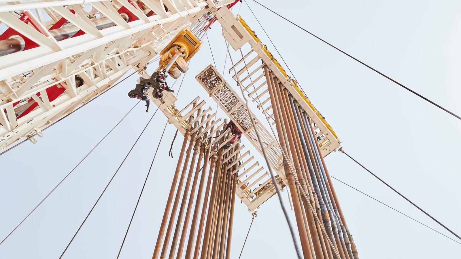A low-angle view of an onshore oil rig structure in Al Wafrah, Kuwait.