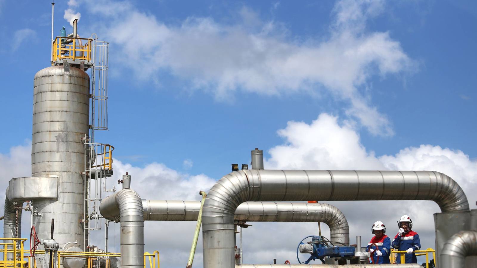 Engineers in hard hats at an industrial gas plant in Lampung, Indonesia.