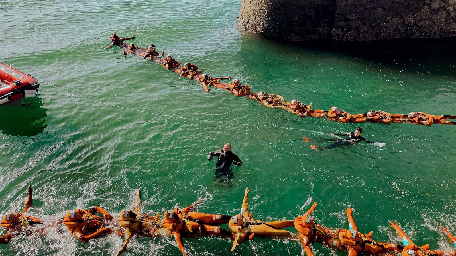 Trainees in orange survival suits during sea survival training
