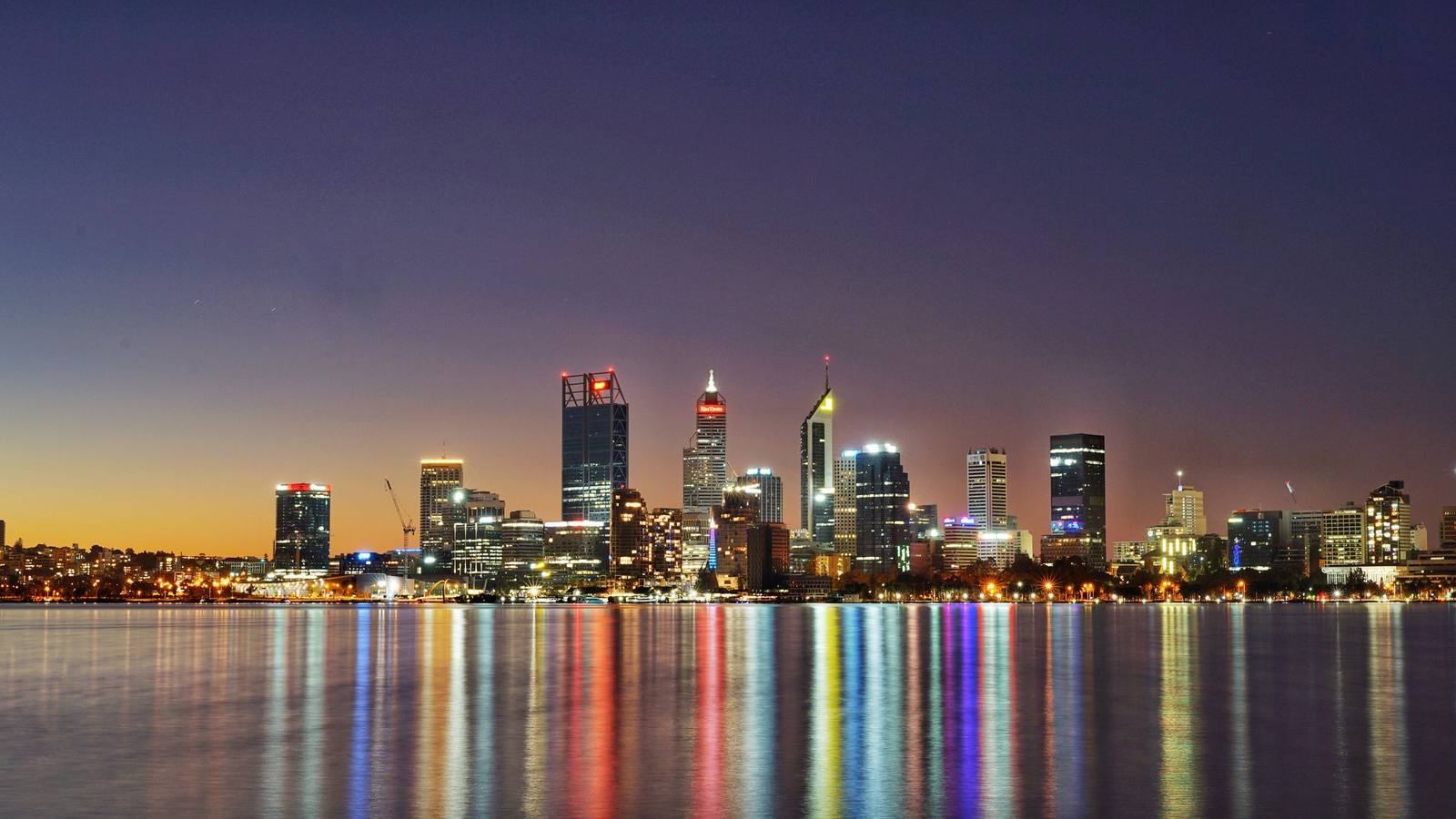 The Perth city skyline reflected in the water at twilight.